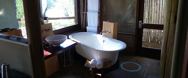 Badezimmer mit frei stehender Wanne in der Rhino Post Safari Lodge