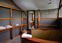 Geräumiges Badezimmer im Ishasha Wilderness Camp, das heiße Wasser für die Dusche wird von außen eingefüllt. &copy; Foto: Svenja Penzel | Outback Africa