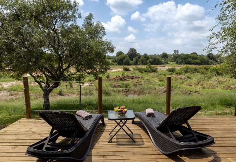 Terrasse mit Sonnenliegen vor den Unterkünften der Umkumbe Safari Lodge © Foto: stew nolan